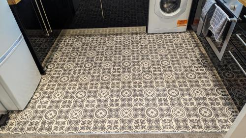 an overhead view of a tile floor with a washing machine at Stylish Condo on Victorian Seafront, Voyagers Rest Bexhill in Bexhill