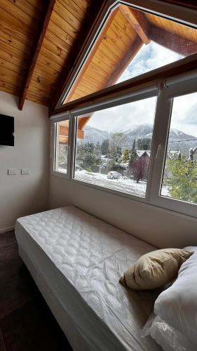 a bedroom with a bed and a large window at ENDOR en VLA in Villa La Angostura