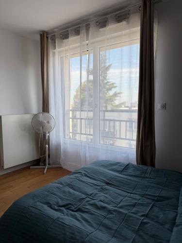 une chambre avec un lit et une grande fenêtre dans l'établissement La chatillonnaise, à Châtillon