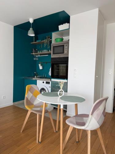 - une cuisine avec une table et deux chaises dans l'établissement La chatillonnaise, à Châtillon