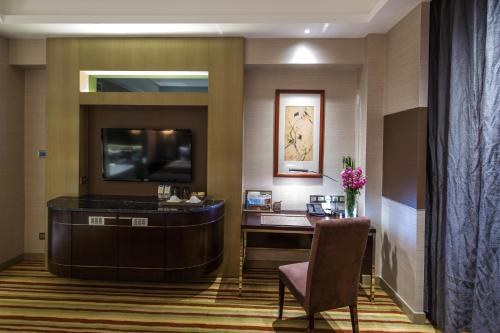 a hotel room with a desk and a television at Millennium Hotel Fuqing in Rongcheng