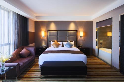 a hotel room with a bed and a couch at Millennium Hotel Fuqing in Rongcheng