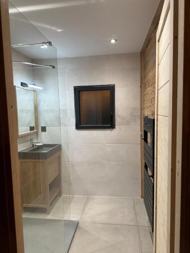 une salle de bain avec un lavabo et une télévision au mur dans l'établissement l'étoile du cambre, à La Cabanasse