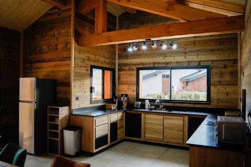 Il comprend une cuisine avec des murs en bois et une grande fenêtre. dans l'établissement l'étoile du cambre, à La Cabanasse