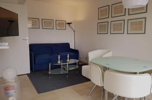 un salon avec un canapé bleu et une table dans l'établissement Centre Cannes Suquet, à Cannes