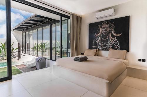 a bedroom with a large bed with a large painting on the wall at Villa Imperial Bliss in Uluwatu