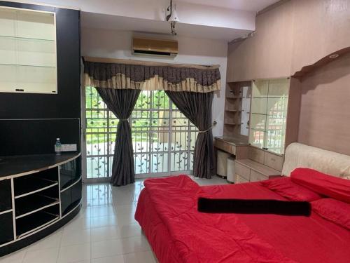 sypialnia z czerwonym łóżkiem i dużym oknem w obiekcie Thind's Place w mieście Kamunting