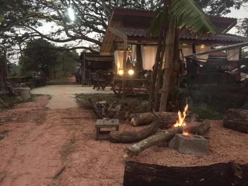 una fogata frente a una casa en OrganicHomeFarmStay, en Ban Na Sông