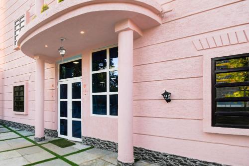 a pink building with an arched doorway at Hotel O M H Club And Resorts in Rānchī