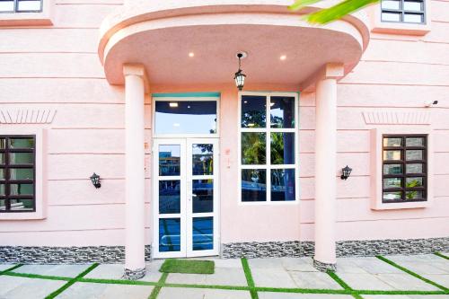 a pink building with a large glass door at Hotel O M H Club And Resorts in Rānchī