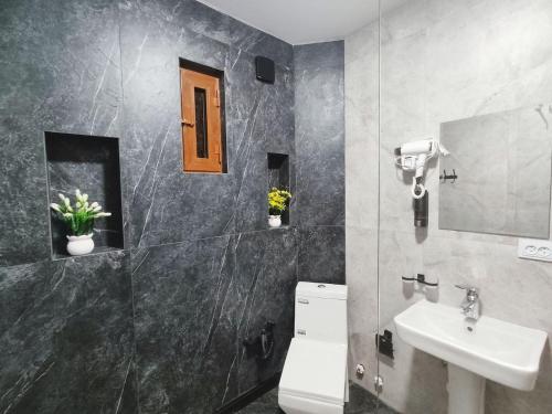 a bathroom with a toilet and a sink at Sahro Hotel in Bukhara