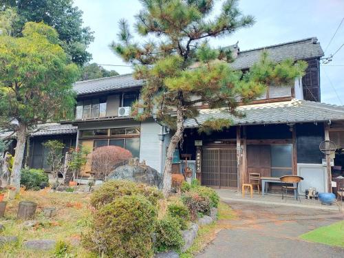 a house with a pine tree in front of it at kamino Terrace, a Japanese history and nature experience accommodation in Wakakuri