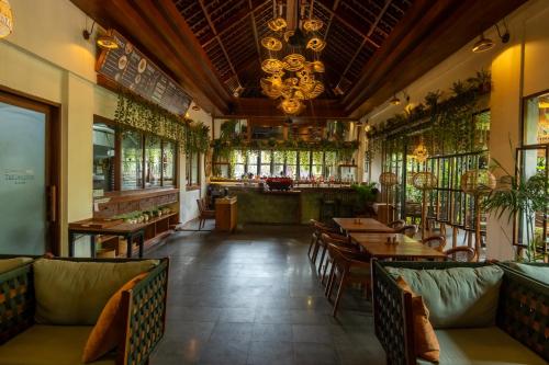 a restaurant with tables and chairs and a bar at Adiwana Suweta in Ubud