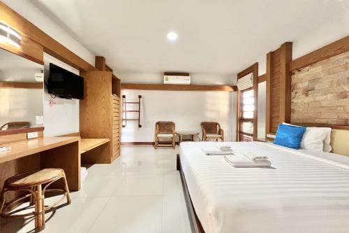 a hotel room with a bed and a tv at Ruentara Resort & Villa in Buriram