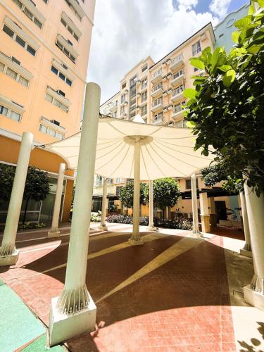 a large white umbrella in the middle of a street at JFam Suites, C4-10R Studio, Up To 4 Pax in Biñan