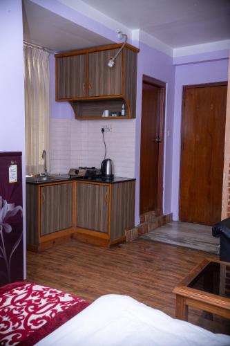 a kitchen with wooden cabinets in a room at k2Homes in Pātan