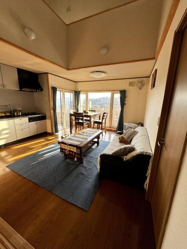 a living room with a couch and a table at Lake Toya Brown House- Great lake views, quiet and spacious in Lake Toya