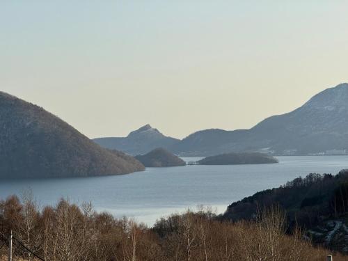 a view of a large body of water with mountains at Lake Toya Brown House- Great lake views, quiet and spacious in Lake Toya