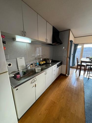 a kitchen with a sink and a table with chairs at Lake Toya Brown House- Great lake views, quiet and spacious in Lake Toya