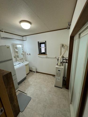 an empty room with a kitchen with a appliance at Lake Toya Brown House- Great lake views, quiet and spacious in Lake Toya