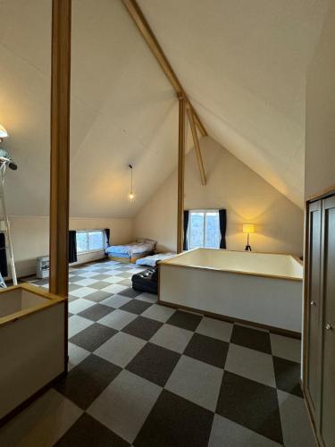 a large attic room with a large bed and a checkered floor at Lake Toya Brown House- Great lake views, quiet and spacious in Lake Toya