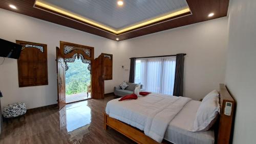 a bedroom with a large bed and a large window at The Sekumpul Villa in Sudaji