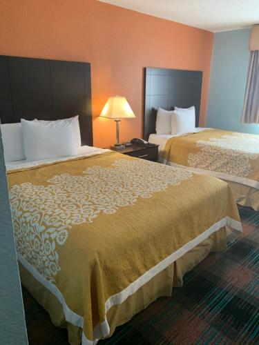 a hotel room with two beds and a lamp at SUNRiSE INN in Greenwood