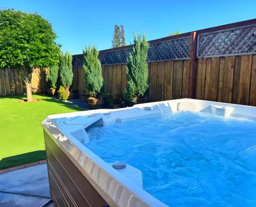 a hot tub in a backyard with a fence at Wine Country King Bed BBQ Stocked in Santa Rosa