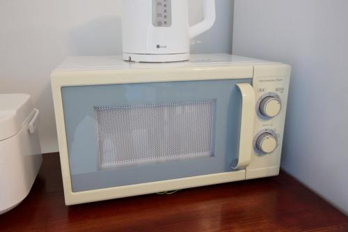 a microwave oven sitting on top of a table at Itomann IN in Sunja