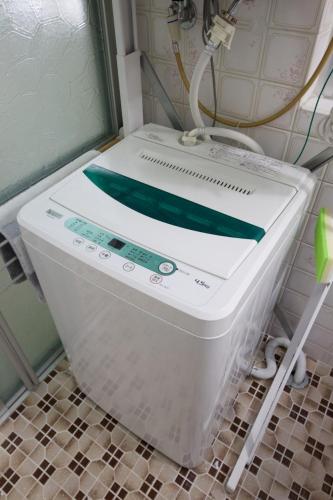 a washing machine with a green ribbon on top of it at Itomann IN in Sunja