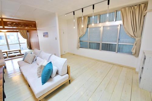 a living room with a white couch and a large window at Itomann IN in Sunja