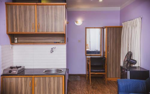 a small kitchen with a sink and a table at k2Homes in Pātan
