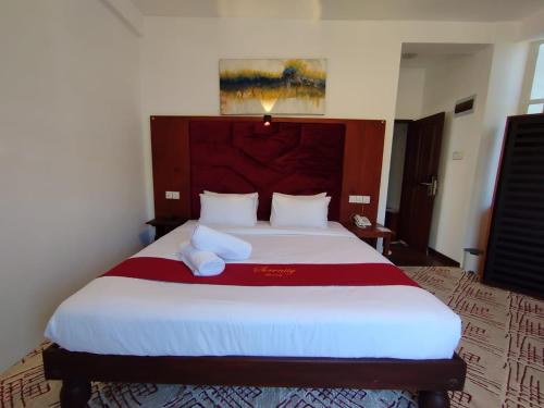 a bedroom with a large bed with a red and white blanket at Serenity Lake Nuwara Eliya in Nuwara Eliya
