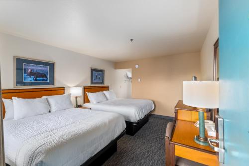 a hotel room with two beds and a lamp at Breeze Inn Hotel in Seward