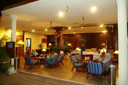 a group of people sitting at tables in a restaurant at Pangkor Bay View Beach Resort in Pangkor