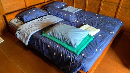 a bed with blue sheets and pillows on it at D sabin cottage in Punten