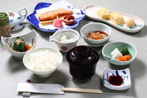 a table topped with bowls and plates of food at 割烹旅館小川荘 in Ōmiya