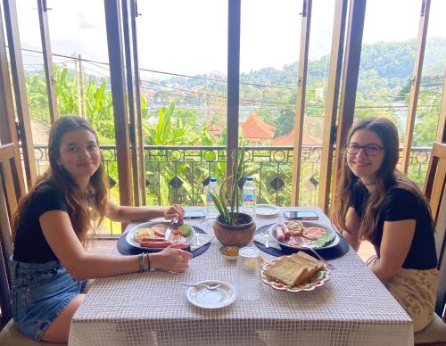 two girls sitting at a table with food at Sesatha lake Kandy in Kandy