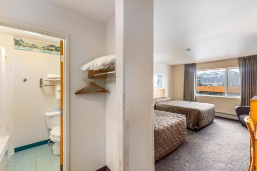 a hotel room with a toilet and a bed at Breeze Inn Hotel in Seward