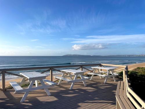 three picnic tables on a deck overlooking the beach at 173 at The Dunes in Keurboomstrand