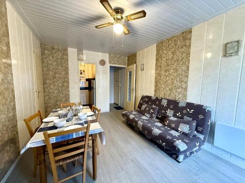 - un salon avec un canapé et une table à manger dans l'établissement Appartement proche plage avec balcon et parking - FR-1-652-53, à Saint-Hilaire-de-Riez