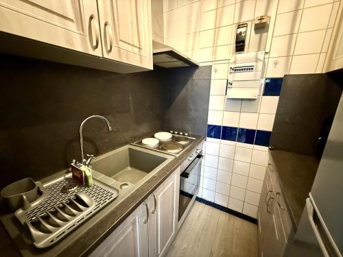 une petite cuisine avec un évier et une cuisinière dans l'établissement Appartement proche plage avec balcon et parking - FR-1-652-53, à Saint-Hilaire-de-Riez