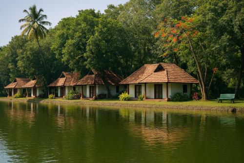 a row of cottages next to a body of water at Taj Kumarakom Resort and Spa Kerala in Kumarakom