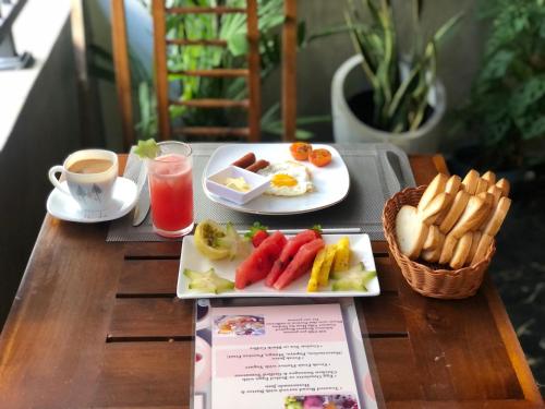 a table with two plates of breakfast food and a cup of coffee at Pebbles villa in Galle