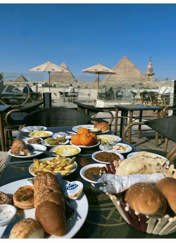 a table with many plates of food on a table with aramids at Locanda Pyramids Hotel in Cairo