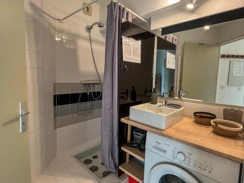 une salle de bain avec un lavabo et une machine à laver dans l'établissement Appartement climatisé en bord de mer avec piscine et parking à Saint-Cyprien - FR-1-753-29, à Saint-Cyprien