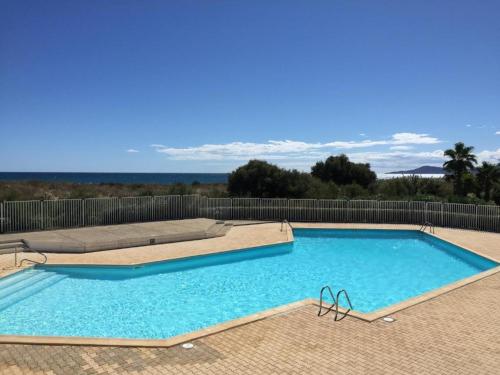 une grande piscine bleue sur une terrasse dans l'établissement Appartement climatisé en bord de mer avec piscine et parking à Saint-Cyprien - FR-1-753-29, à Saint-Cyprien