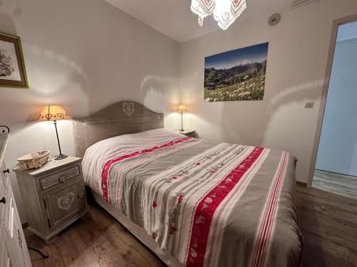 - une chambre dotée d'un grand lit et d'une table de chevet avec une sidx sidx dans l'établissement Charmant logement pour 2 personnes à Villard-de-Lans - FR-1-515-225, à Villard-de-Lans