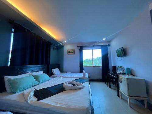 白马市Au Paradis Bleu Hotel的蓝色灯的客房内的两张床