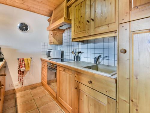 une cuisine avec des armoires en bois et un évier dans l'établissement Spacieux T4 aux Gets près des pistes avec terrasse - FR-1-685-86, aux Gets